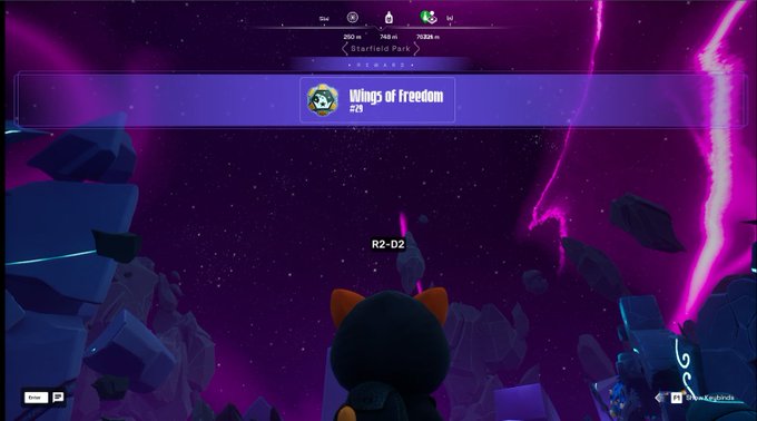 The image shows a space-themed scene with a black cat character looking up at an achievement notification reading "Wings of Freedom 2/3" along with a name "R2-D2" floating nearby, in front of a purple cosmic background with floating debris. This visually captures the moment the player earned the "Wings of Freedom" badge in the Nexus, as referenced in the accompanying post.