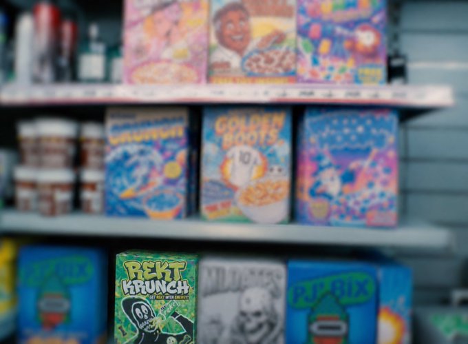 A blurred store shelf displaying colorful cereal boxes including 'Golden Boats', 'Rekt Krunch', and 'Mildewys' with skull-themed artwork.