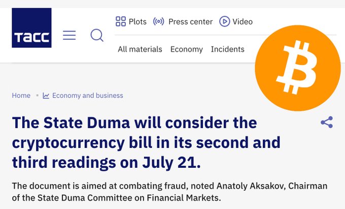 The image is a TASS news article with the headline "The State Duma will consider the cryptocurrency bill in its second and third readings on July 21," quoting Anatoly Aksakov, Chairman of the State Duma Committee on Financial Markets. A Bitcoin logo is featured in the top right corner. The article relates to the post by reporting on Russia's State Duma's scheduled vote on cryptocurrency regulation legislation.