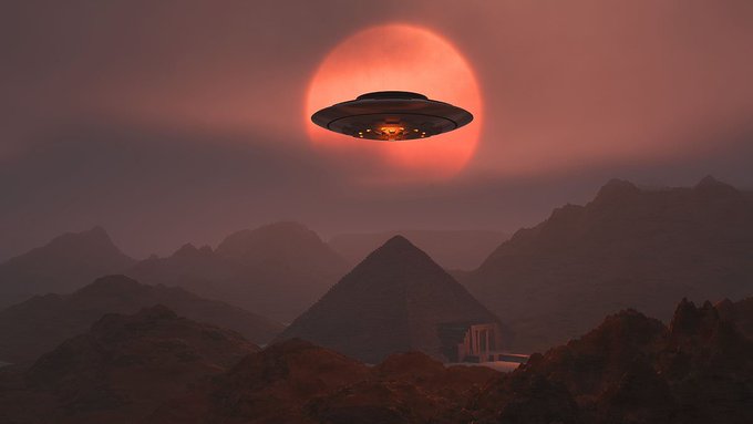 A classic flying saucer UFO hovers in front of a massive red moon, with the Great Pyramid and smaller pyramids silhouetted against a hazy desert landscape below.