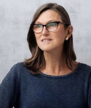 A woman with shoulder-length brown hair and dark-rimmed glasses smiles in a professional portrait, likely representing a leader or spokesperson associated with ARK Invest's launch of its tokenized venture fund on Ethereum.
