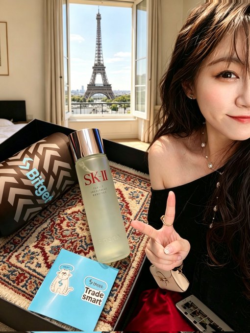 The image features a woman posing with two bottles of Skii facial mist, one being a white bottle and the other a red one. The woman is wearing a black top and has her hand raised in front of her face, possibly for a selfie or to show off the skii products. The background includes a window overlooking the Eiffel Tower, which adds an interesting visual element to the photo. The image also contains text that reads "bitget", which could be related to the Skii facial mist or another product featured in the picture.