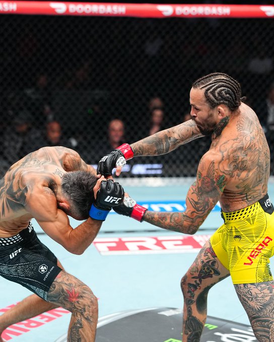 Marlon "Chito" Vera lands a devastating elbow strike on his opponent inside the UFC octagon during UFC 331, showcased with "DOORDASH" branding visible on the cage padding as the fight streams live on Paramount+. The image perfectly captures Vera's signature aggressive striking style that earned him the "Vintage Chito" acclaim referenced in the post.