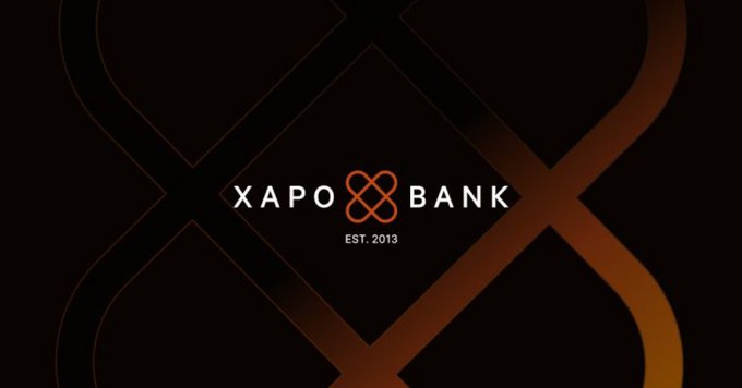 The image displays the Xapo Bank logo with "EST. 2013" on a dark background featuring orange geometric patterns, serving as branding for the "Crypto Bear Market Survival Guide" sponsorship.