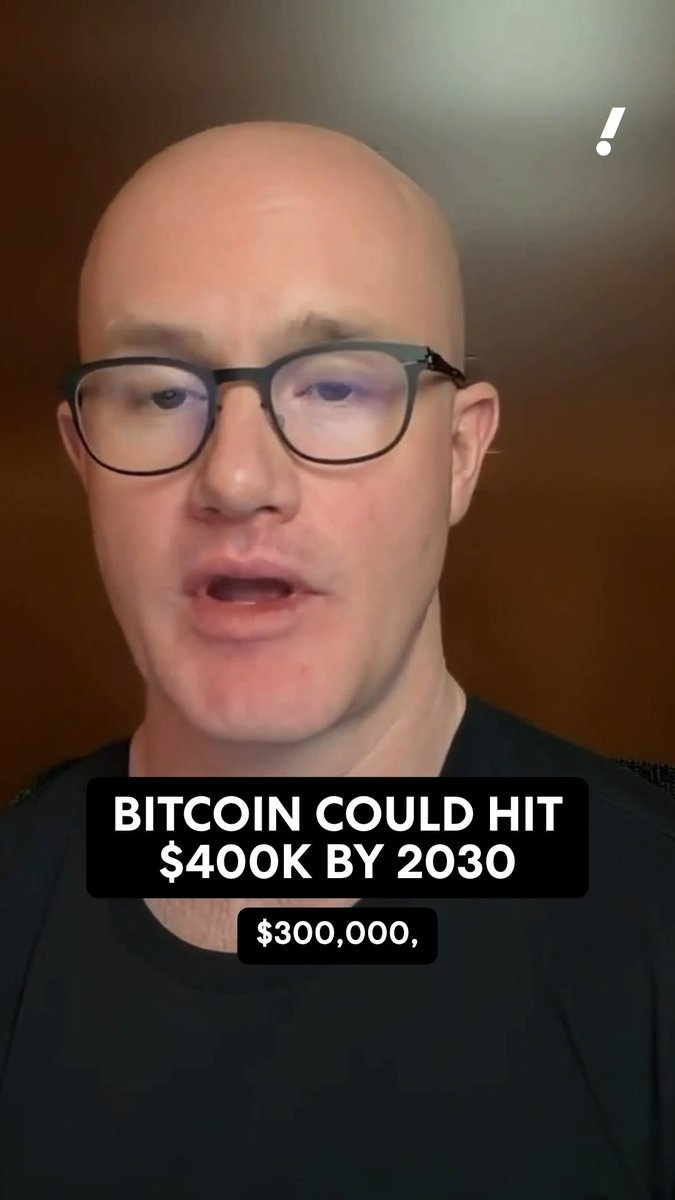 A bald man with black glasses and a black shirt speaks to the camera, with on-screen text reading "BITCOIN COULD HIT $400K BY 2030" and "$300,000," accompanied by a white exclamation point in the corner, illustrating Coinbase CEO Brian Armstrong's bullish prediction for Bitcoin's future price.