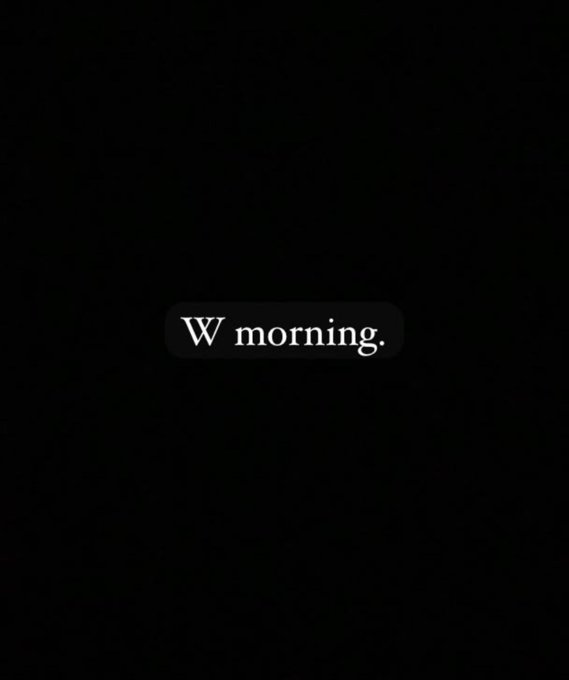 A dark, minimalist image with a small black pill-shaped label in the center containing white text reading 'W morning.'