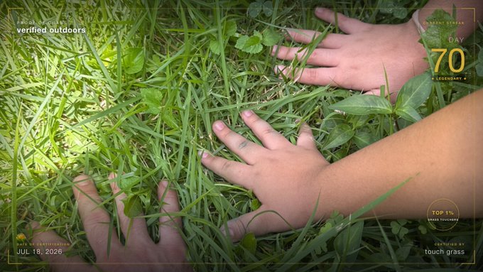 Two hands are shown touching green grass in a top-down view, with overlay text including 'verified outdoors', 'Day 70', and 'CAPTURED JUL. 18, 2026 touch grass'.