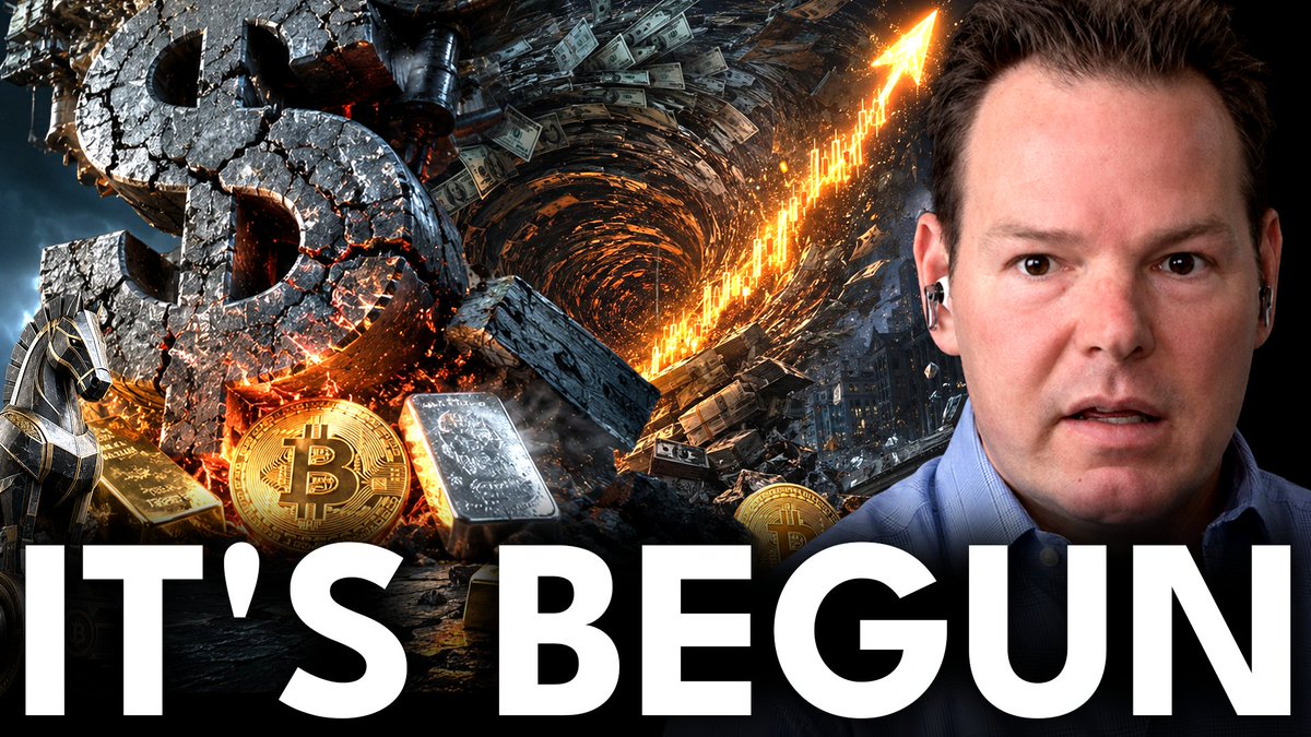 A YouTube thumbnail featuring a man with earpieces on the right side, with dramatic imagery on the left showing a broken dollar sign, gold bars, Bitcoin coins, silver, burning currency, and an upward-trending chart with an arrow. The bold text "IT'S BEGUN" appears at the bottom, visually reinforcing the podcast's discussion about rising debt, the devaluation of the dollar, and the case for owning gold, Bitcoin, and silver.