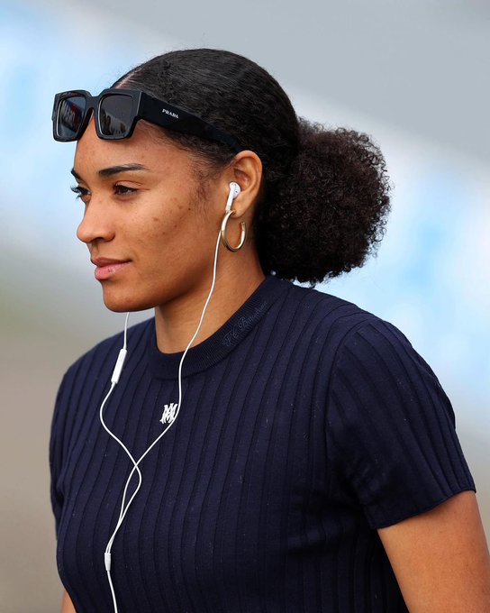 The image shows a woman wearing sunglasses, a black shirt, and headphones while standing next to a building. The photo has been edited to include text that reads "@PythNetwork build. learn. stay early with @PythNetwork". This suggests that the image is related to a social media post or news article about the MakerDAO project on the Ethereum blockchain.