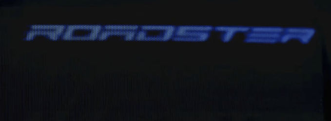 A dark image showing the word "RIDDLE" in a stylized blue LED-style font on a black background.