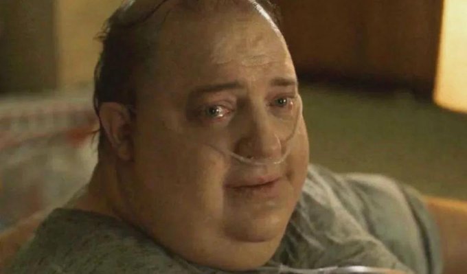 A close-up photograph of a tearful, emotional bald man with a nasal cannula, appearing to be from a movie scene.