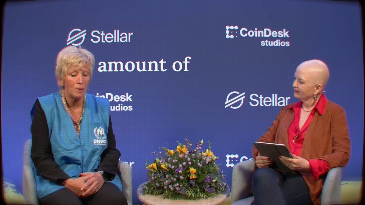 A woman wearing a UN High Commissioner for Refugees (UNHCR) vest sits across from a moderator during a panel discussion on a stage branded with "Stellar" and "CoinDesk studios" logos, with partial on-screen text reading "amount of."

The image ties to the post through visible **$XLM** (Stellar) branding at a CoinDesk event featuring a UNHCR guest speaker.