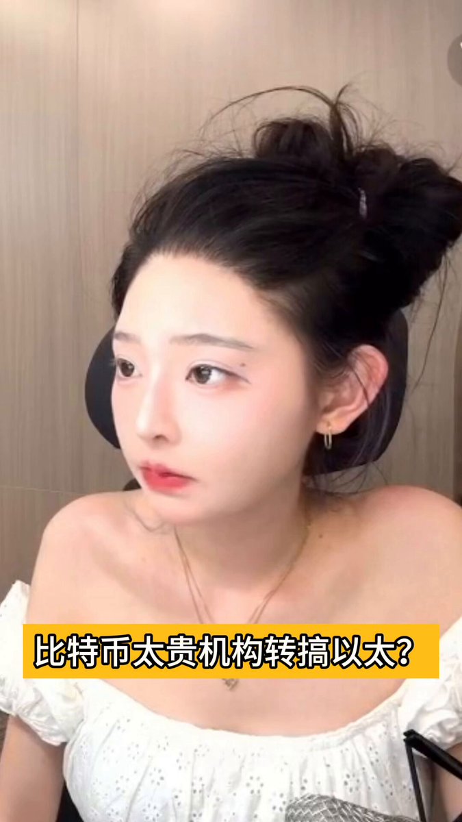 The image features a woman with her hair styled into a bun, wearing a white top. The caption of the image reads "以太坊被质疑不涨时，恰恰该买入了". This phrase is likely an inside joke or reference to a specific event, and it adds context to the image. The woman's hairstyle and attire suggest that she might be attending a formal event or simply prefers a neat appearance for her daily activities.