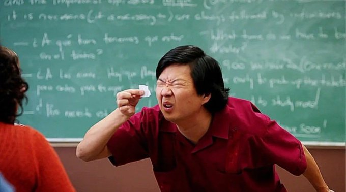 A still from the film 'Parasite' showing a man in a maroon shirt aggressively spitting while standing in front of a chalkboard filled with equations.