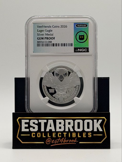 A graded 'VeeFriends Coins 2026 Eager Eagle Silver Medal GEM PROOF' coin in an NGC slab (serial 8855610-088) sits on a black display stand branded with 'ESTABROOK COLLECTIBLES @est4brook'.