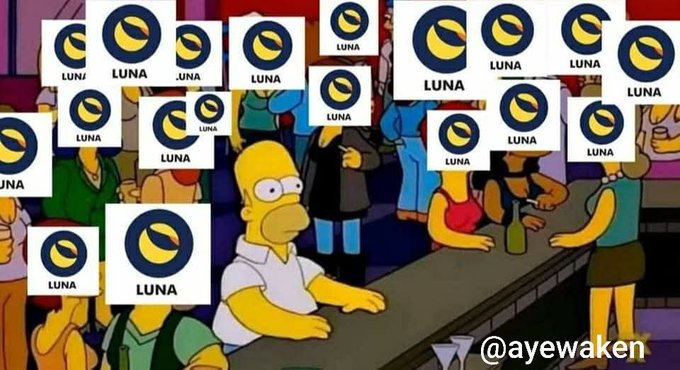 A Simpsons bar scene featuring Homer surrounded by numerous "LUNA" cryptocurrency logos overlaid across the image, watermarked with "@ayewaken".