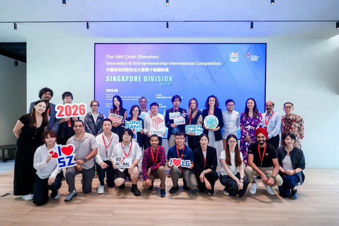 A group photo of participants and organizers at "The 10th China (Shenzhen) Innovation & Entrepreneurship International Competition" with "Singapore Division" displayed on the screen behind them.