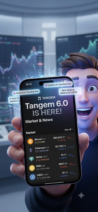 A promotional image for 'Tangem 6.0 IS HERE!' featuring a smartphone displaying crypto market prices (Bitcoin, Ethereum, Tether, BNB, USDC) with a cartoon character in the background.