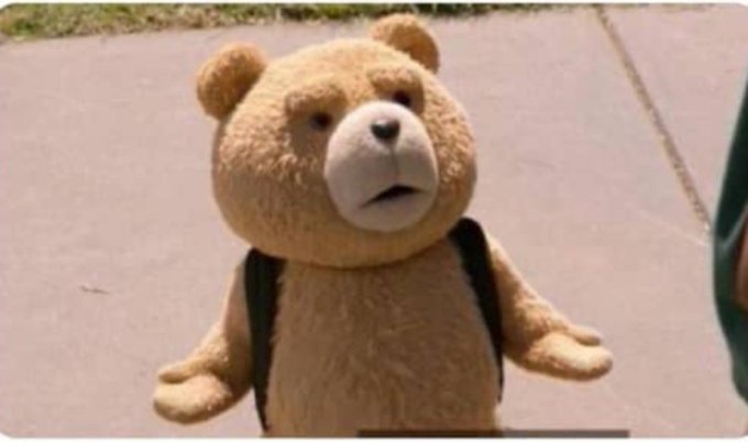 A CGI teddy bear (resembling Ted from the 2012 film) stands on a sidewalk wearing a backpack with a confused expression. The post humorously pairs this bewildered-looking bear with text expressing exaggerated confusion and disinterest in a question about withdrawing from a Prediction market.