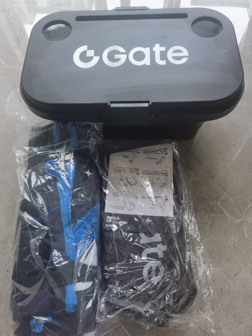 A black 'Gate' branded case and matching clothing items wrapped in plastic, appearing to be merchandise packaging.
