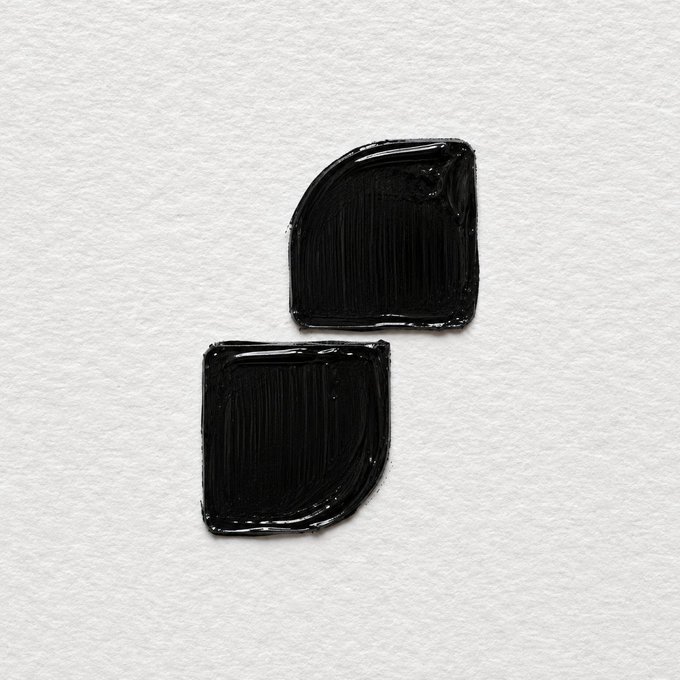 The image features two black squares placed side by side against a white background. The squares are identical in size and shape, creating a sense of balance within the composition. The arrangement of these squares suggests that they might be part of an art project or design concept.