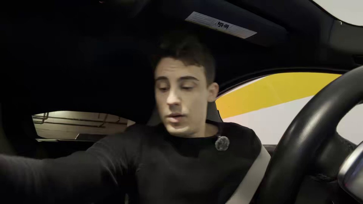 The main focus of this image is a man sitting behind the steering wheel in a car. The man appears to be looking out of the window with interest, possibly taking in his surroundings or observing something outside. He might be driving down the street at night, as suggested by the darkness and potentially illuminated streetlights around him. There's also an additional description related to a $200 giveaway for an All-In series video. The man's position behind the wheel suggests that he is likely controlling the vehicle and possibly participating in the promotion, though without more context or information about the content of the image itself, we cannot confirm this claim definitively.