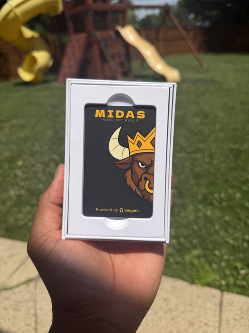The image features a hand holding up a wallet with a cartoon bull's head design on it. The wallet has a white box around it, which contains a card inside. The person holding the wallet appears to be showing off their new purchase or possibly sharing an interesting story about the wallet.