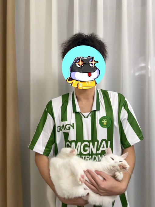 A person in a green and white striped GMGN jersey with "TRADING" text holds a white cat, their face covered by a pixel art cartoon sticker, announcing their signing as captain of the Gmgn soccer team with humor about a modest salary from "Chicken Bro."