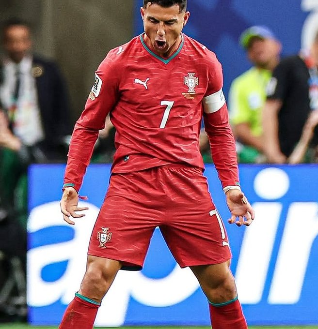 Cristiano Ronaldo in a red Portugal national team kit bearing the number 7, yelling passionately during a match.