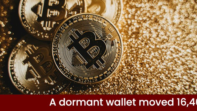 A close-up of gold Bitcoin coins rests on a textured gold surface, with the prominent coin displaying "DECENTRALIZED PEER TO PEER" and "DIGITAL CURRENCY" engravings, visually reinforcing the post about a dormant wallet transferring 16,400 bitcoin (worth $1.04B) to a new address after seven months of inactivity.