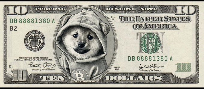 A modified US ten-dollar bill featuring a Shiba Inu dog wearing a hoodie in place of Alexander Hamilton, with a Bitcoin 'B' logo replacing Hamilton's name.