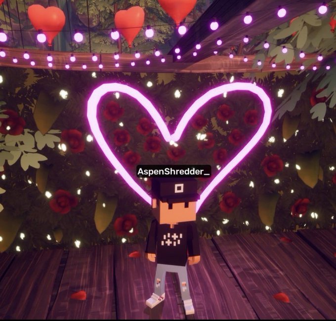 Minecraft-style avatar labeled 'AspenShredder_' standing beneath a glowing pink neon heart, surrounded by red roses, floating hearts, and string lights.