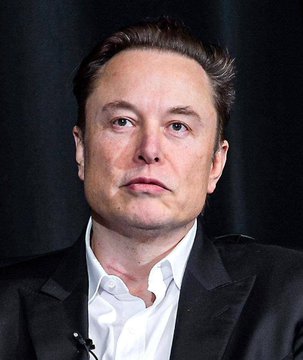 The image shows a close-up portrait of Elon Musk, a middle-aged man with short brown hair, wearing a black blazer over a white collared shirt against a dark background. The caption accompanies his statement about AI and Optimus technology revolutionizing healthcare, visually connecting his face to the ambitious claim about future medical advancements.