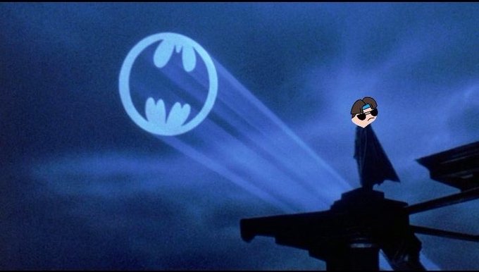 An animated scene showing a figure in a cape standing on a structure projecting a bat-signal into a dark night sky.