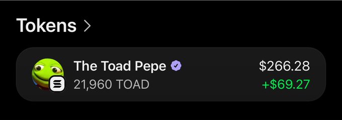 A screenshot of a crypto wallet showing a token balance of 21,960 TOAD ("The Toad Pepe") valued at $266.28, with a green gain of +$69.27, supporting the post's claim of winning 21,960 $TOAD tokens from pre-registering for Cade Market's meme tournament.