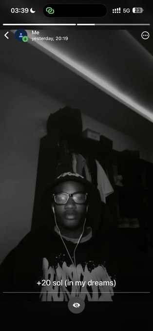 A dark Snapchat screenshot showing a person wearing glasses, earphones, and a hoodie with the caption '+20 sol (in my dreams)'.