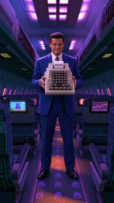 A man in a blue suit standing in a futuristic purple-lit room holding a vintage computer labeled "SODOTECH".