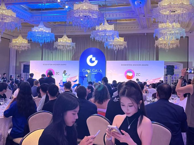 A large gala event takes place in an ornate hall with chandeliers, featuring an 'ECOSYSTEM ANCHOR AWARD' presentation with 'ZC' logos displayed on screens.
