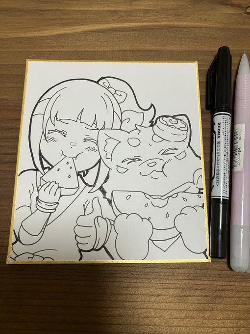 A black and white ink drawing of an anime-style girl eating watermelon next to a cat, displayed on a wooden table next to a Zebra Zebruland marker and a brush pen.