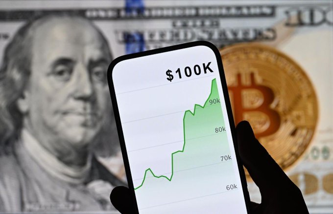 The image features someone holding up their phone with a graph displaying the price of Bitcoin and another currency next to it. The text in the image states, "Focus on what is in the image and how it relates to the post". This implies that the person might be discussing or explaining the details of the graph they are holding up or showcasing to someone else using their phone as a reference point for comparison.