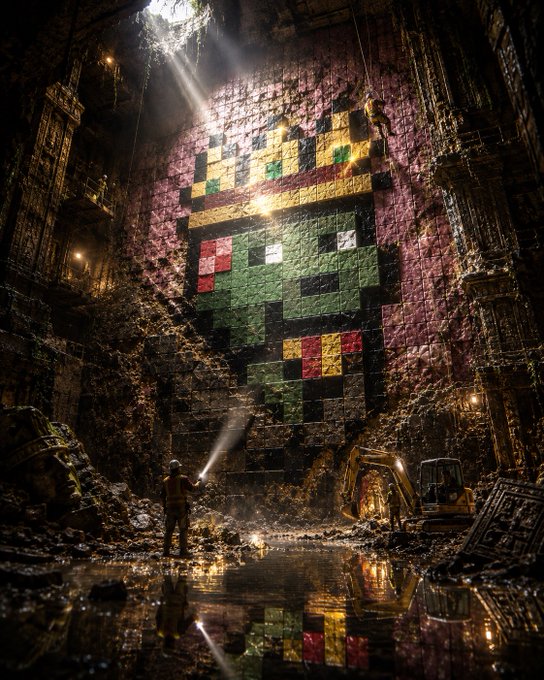 A cinematic, dark fantasy illustration of a cavernous underground chamber where a lone figure illuminates a massive pixel-art mosaic of Link from The Legend of Zelda painted on the ancient brick wall, with an excavator visible in the background.