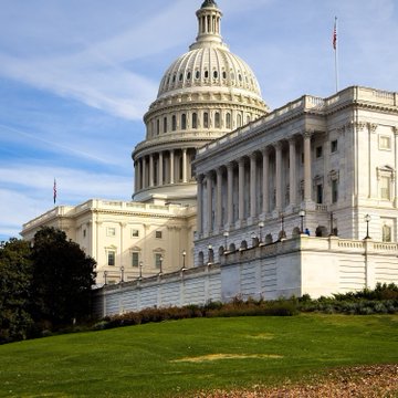 The U.S. Capitol building stands under a clear blue sky, symbolizing the federal government and regulatory bodies referenced in the survey results about regulatory clarity driving onchain adoption.