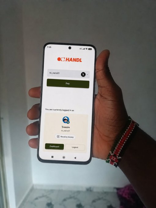 A hand holds a smartphone displaying the HANDL payment app, showing a logged-in account for 'Tunero' with options to pay, receive money, and access the dashboard.