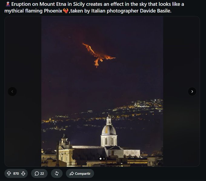 Nighttime photograph of an eruption on Mount Etna in Sicily, with the glowing lava flow appearing to take the shape of a mythical flaming Phoenix over a town below; the caption credits Italian photographer Davide Basile.