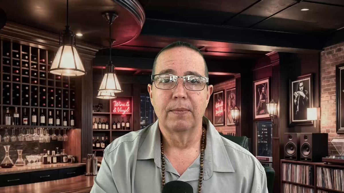 The image features a man wearing glasses, sitting at a bar with several bottles behind him. The man appears to be talking into a microphone or recording device, possibly discussing something related to cryptocurrency or the Bank of America's involvement in it. The caption reads "Bank of America Join Crypto-XRP Patent? youtu.be/Uzp4-preDfM". This suggests that there might be an ongoing conversation about the patent application by the Bank of America and the crypto company, which could potentially impact the future of cryptocurrency or other digital assets.