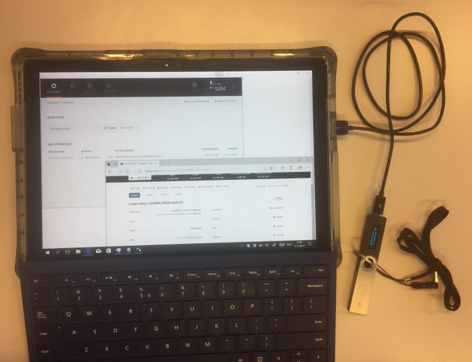 A tablet with an attached keyboard sits on a desk displaying a webpage for "Ledger Baby LEGER ETHER ADDRESS", connected via a USB hub and cable.