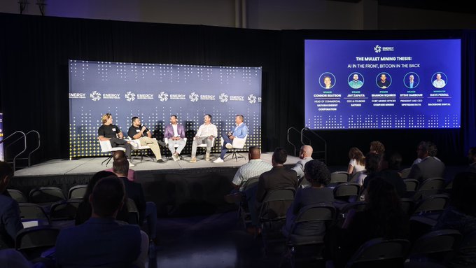 A panel discussion at a conference with five men seated on stage; the screen displays 'THE BIGGEST MINING THING: AI IS THE FRONT, BITCOIN IN THE BACK' with speaker headshots.