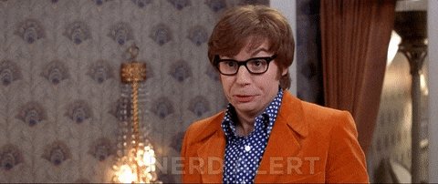 The image features an actor dressed in a bright orange suit with glasses standing next to a lamp. A caption below the image reads "Good morning, $XRP family! Have a wonderful day!" The actor's facial expression suggests that he might be posing for the photo or giving a speech related to cryptocurrency.