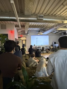 The slide isn't clear enough to read, but it does appear that someone is giving a presentation to a group of people seated together. The accompanying text "AgentCash 2 coming soon" may refer to the presentation's subject, which could possibly be a product or a business debut.