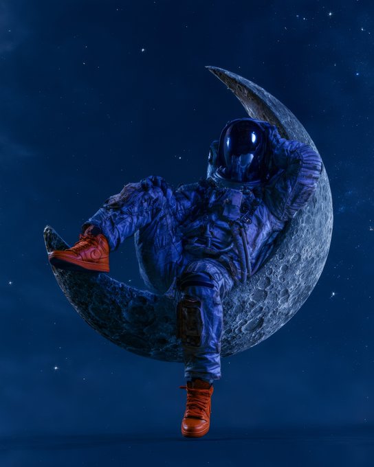 An astronaut in a blue spacesuit and orange sneakers sits casually on a crescent moon against a starry night sky background.